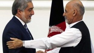 Afghan rival presidential candidates Abdullah and Ghani shake hands after exchanging signed agreements for the country's unity government in Kabul
