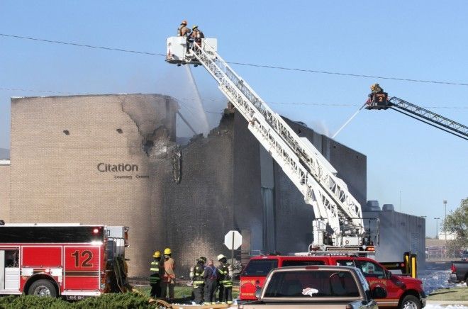 Firefighters try to put out a fire at Mid-Continent Airport in Wichita, Kan. on Oct. 30, 2014 shortly after a small plane crashed into the building killing several people including the pilot.