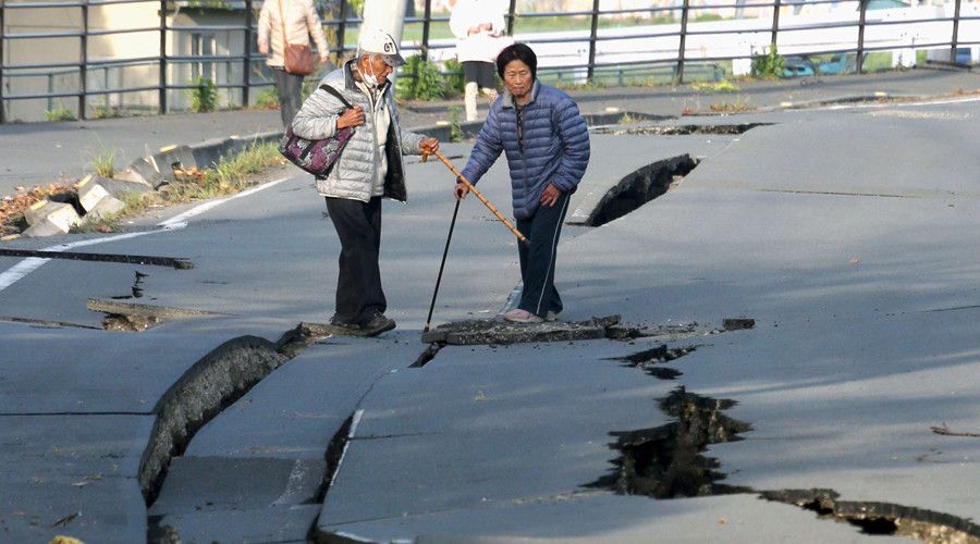 Local residents look at cracks caused by an earthquake on a road in Mashiki town, Kumamoto prefecture, southern Japan, in this photo taken by Kyodo April 16, 2016. © Reuters 