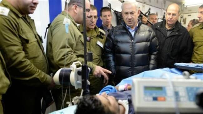 Israeli Prime Minister Benjamin Netanyahu, third right, visits a militant wounded in Syria at a field hospital in northern Israel, February 2014.