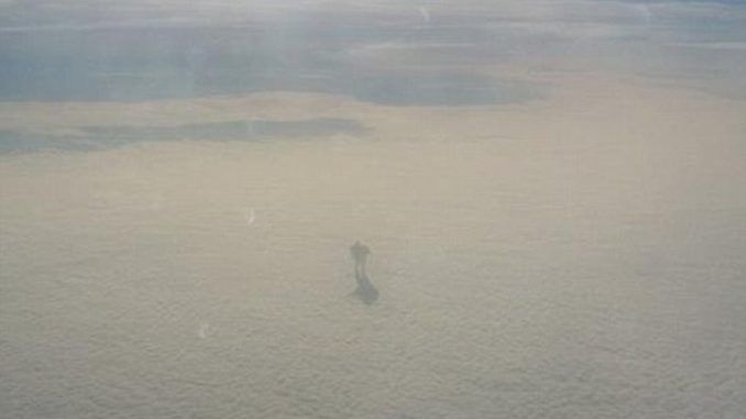 Airplane passenger captures weird humanoid creature walking across a cloud