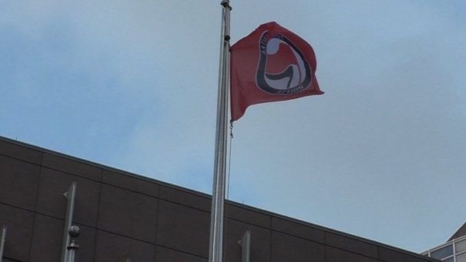 Leftist protestors stormed a government building in Minnesota on Monday, lowering and partially burning an American flag before hoisting an Antifa flag in its place.