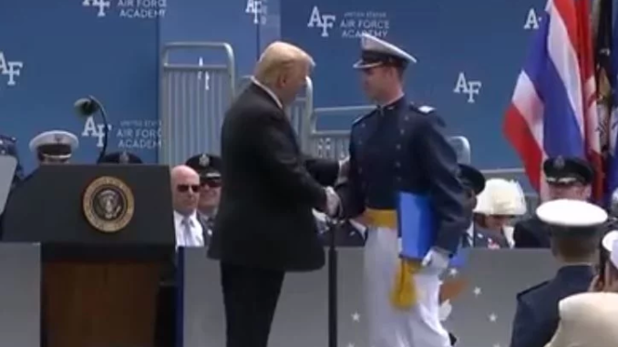President Trump stands, salutes and shakes hands with 900 cadets