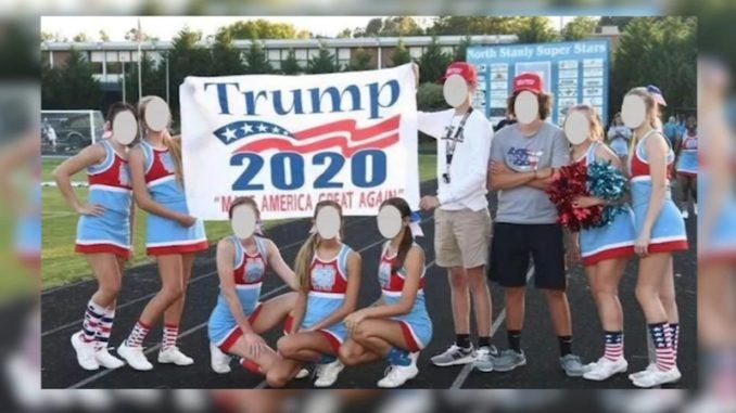 High school cheerleaders at a North Carolina school have been put on probation after posing with a Trump 2020 banner.