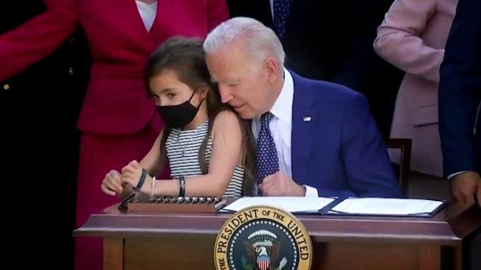 President Joe Biden grabs little girl during bill signing at the White House