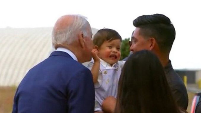 Baby cries out in terror as Joe Biden leans in for his signature sniff and kiss