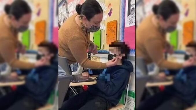 Parents horrified after Democrat teacher photographed taping a mask to a young child's face